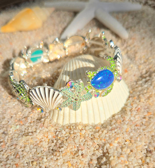 Brazalete decorada con estrellas de mar en vidrio marino tornasol