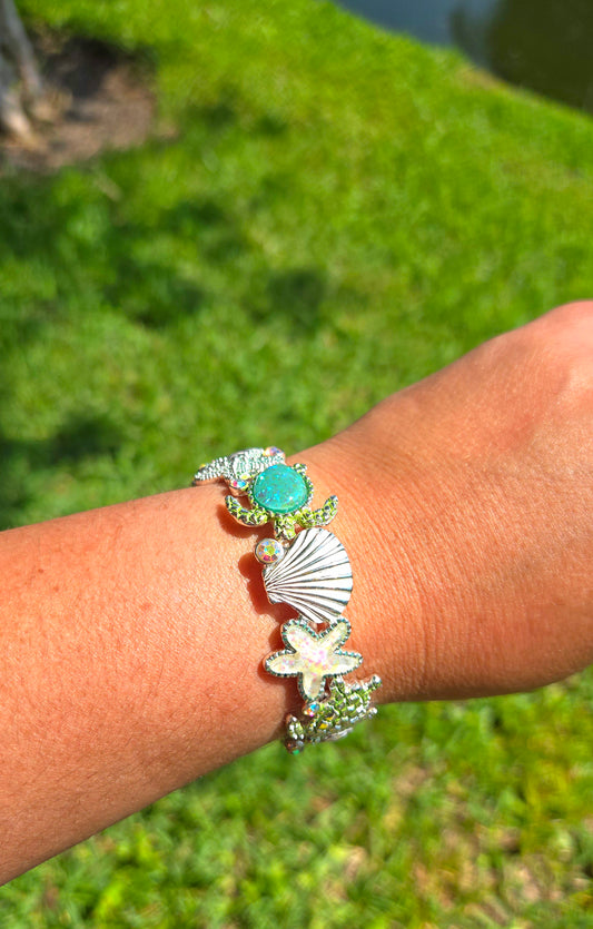 Brazalete decorada con estrellas de mar en vidrio marino tornasol