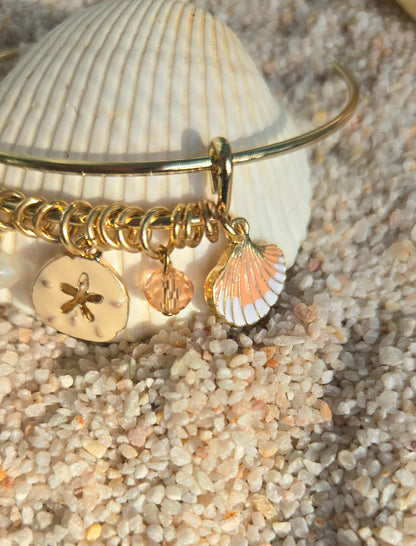 Pulsera bangle dorada decorada con concha, estrella de mar y cristales